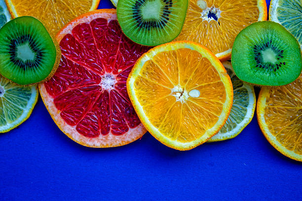 istock Colorful Citrus And Kiwi Fruit Slices Arranged On A Bright Blue Background. 2224563495