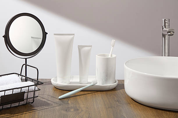 istock Minimalist bathroom sink with mirror, ceramic dispensers, and toothbrush in a tray. Ample negative space for product placement. Clean and modern self-care vibe. 2224567207