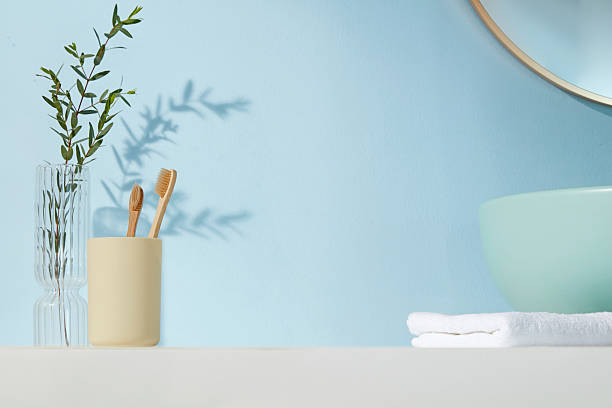 istock Minimal feminine bathroom with bamboo toothbrushes in soft holder, clear vase with greenery, and light blue background. Gentle, fresh and nature-inspired. 2224567290