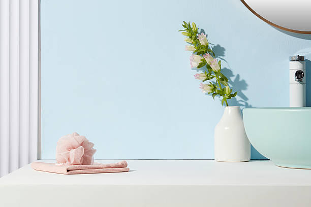 istock Minimalist blue bathroom with blush pink towel and bath sponge. Open counter space with soft natural light, perfect for product showcasing. 2224567304