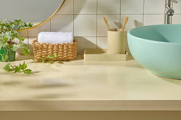 istock Wicker basket with white towel, green basin, bamboo toothbrushes on beige counter. Bright natural light and tiled wall create a soft, minimal bathroom scene with clear space. 2224567357