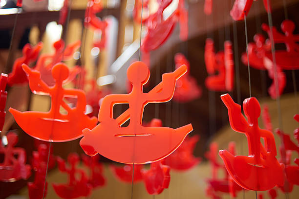 Red Decorative Figures Hang Gracefully in an Indoor Space, Creating a Whimsical Ambiance Through Playful Design