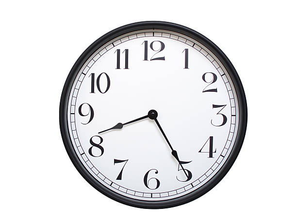 istock Round analog wall clock with a black frame, white face, and bold black numerals. showing  08:25 or 20:25. Isolated on a white background. Ideal for time-related themes. 2224577378