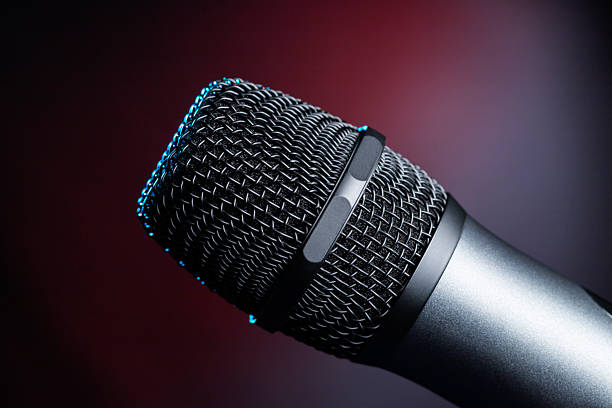 istock Close-up of microphone in studio or concert performance on stage, on black background. 2224578198