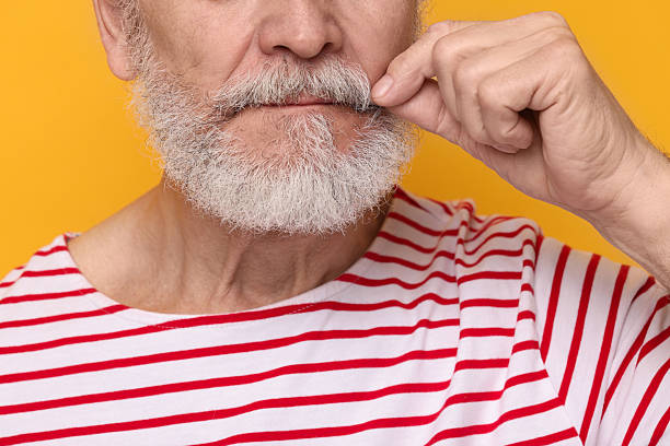 istock Man touching mustache on orange background, closeup 2224578315