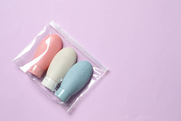 istock Cosmetic travel kit in plastic bag on violet background, top view. Space for text 2224578998