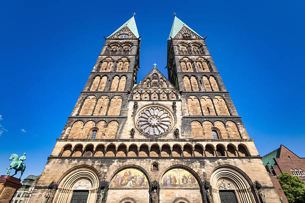 The Bremen Cathedral - Dom St. Petri built in the 11th century in Bremen, a historical landmark with its imposing twin towers at Bremen's Market Square, stands tall against a blue summer sky. Otto von Bismarck Equestrian Statue on the left. Bremen City, Bremen, Northern Germany, Central Europe