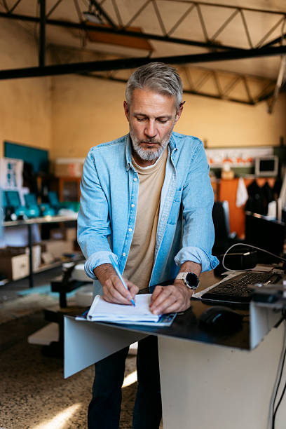 istock Mature adult man writing in office environment 2224581475