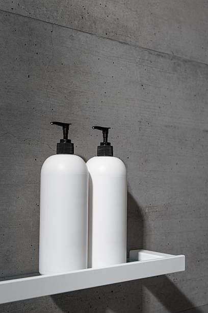 istock White bottles mock up on white shelf on gray concrete background, close up shampoo, conditioner. Aesthetic view beauty products in modern minimal bathroom neutral color. Side view, copy space 2224581499