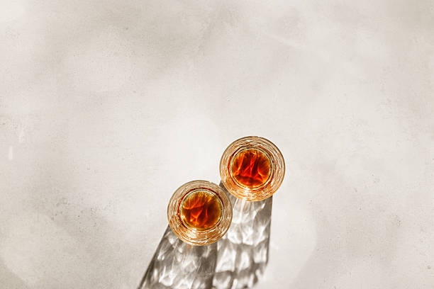istock Crystal Whiskey Glasses with shadows at sunlight on beige concrete background, minimal aesthetic top view shiny glasses, sun glare, stong alcohol drink concept, summer still life top view, copy space 2224581593