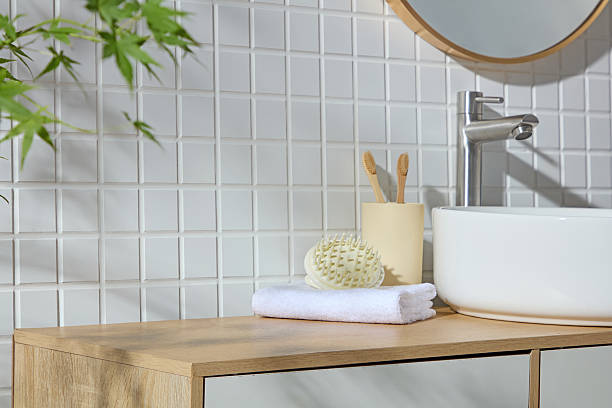 istock White sink beside bamboo toothbrushes, sponge, and towel on a wood surface. The soft greenery and clean layout create a Nordicinspired setting with room left for product visuals. 2224582957