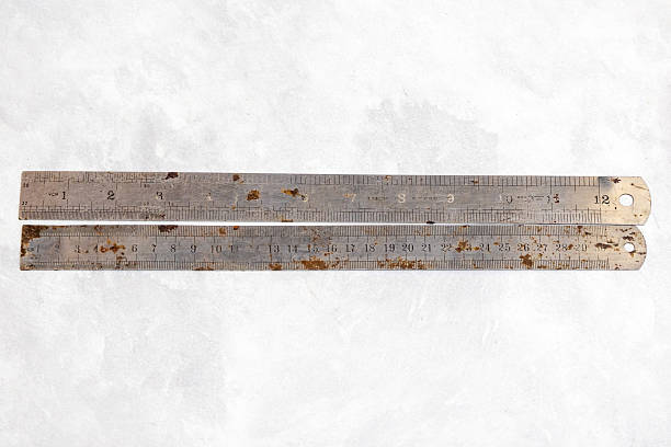 istock Two aged 12-inch stainless steel rulers displaying rust. Essential vintage measuring tools showing wear and tear. 2224583414
