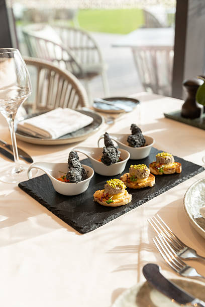 Elegant appetizers canapes with foie gras, fish and avocado served as starter in luxury fine dining restaurant for lunch