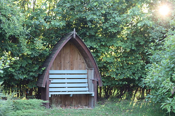 Wooden garden arbour against a hedge