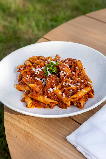 Pasta penne arrabbiata bolognese with fresh basil meat sauce served in Italian outdoor restaurant