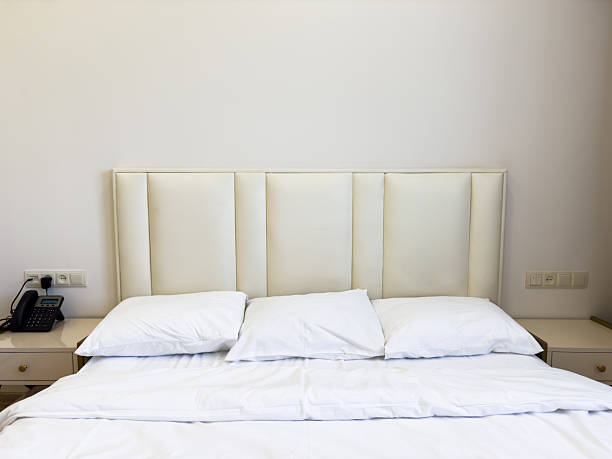 istock A white bed with a phone on the nightstand 2224588177