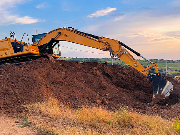 istock Excavator on Dirt Hill with Cloudy Sky 2224591922