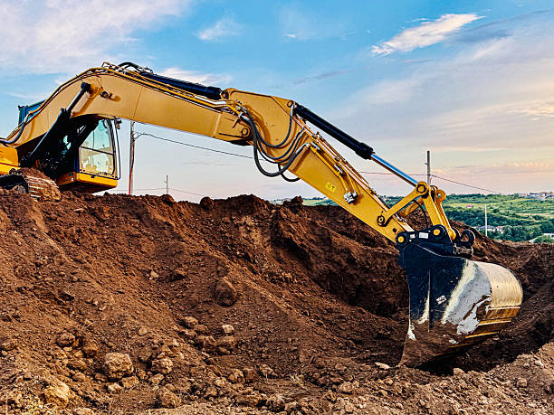 istock Excavator on Dirt Hill with Cloudy Sky 2224591925