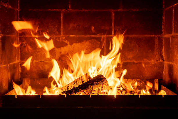 istock Brick fireplace lit with wood fire, strong bright flames, creating interior comfort, rural cozy evening, winter heat, peaceful countryside atmosphere 2224594135