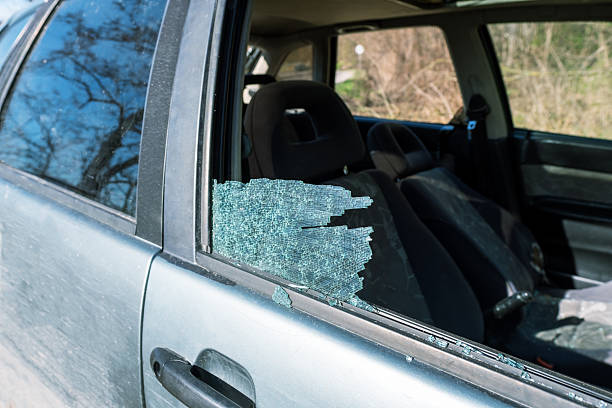 istock Realistic urban car crime image, broken glass remaining in window frame, vehicle left damaged, representing personal property theft, vulnerability on road 2224594146