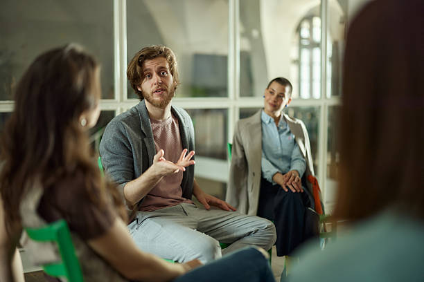 istock Young man talking to his colleagues on a group therapy. 2224599294