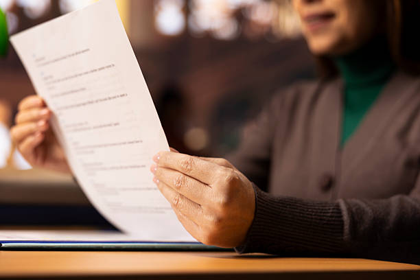 istock Mature student reviews paperwork for her degree in a classic library setting 2224599753