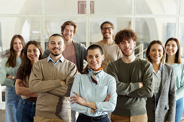 istock Happy creative team with crossed arms in a modern office. 2224599894
