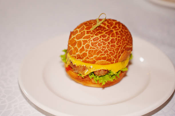 Mini burger with patty, cheese, tomato and lettuce. A convenient and delicious snack for a buffet or children's party.