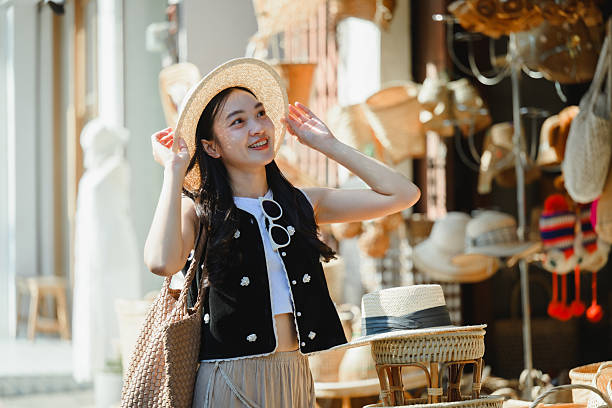 istock Young tourist adjusting her straw hat while visiting a traditional Thai market 2224602880