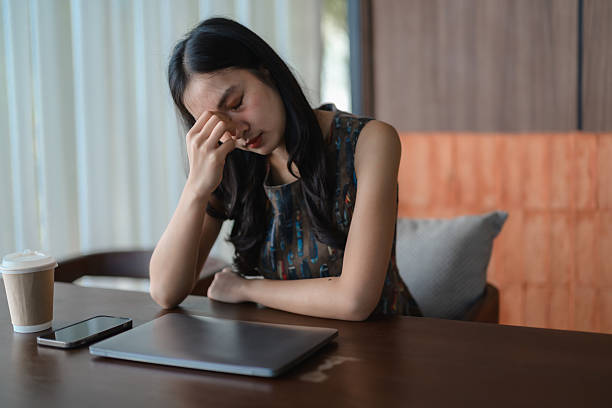 istock Stressed young asian businesswoman having headache while working on laptop in cafe 2224603220