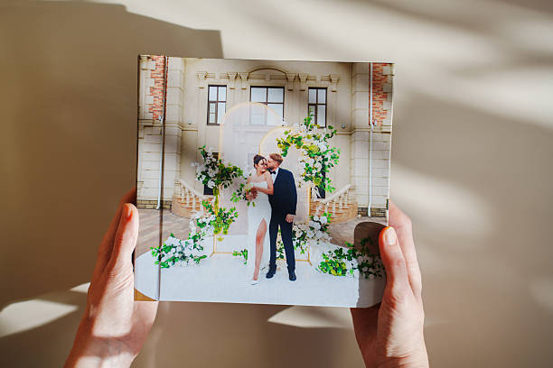 istock hands with a photo book with wedding photos on a white table 2224603418