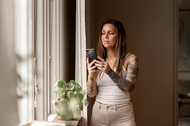 istock Woman interacting with smartphone in a cozy home environment 2224604371