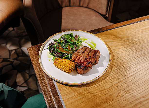 istock Delicious grilled steak with corn and salad at a cozy restaurant setting 2224605185