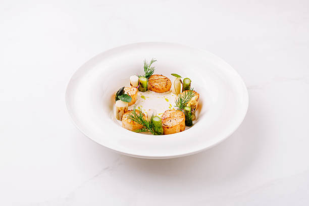 istock Seared scallops with herbs, served elegantly in a bowl 2224607115
