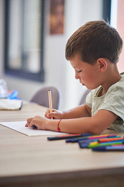 istock Boy drawing quietly at home with colored markers 2224607236