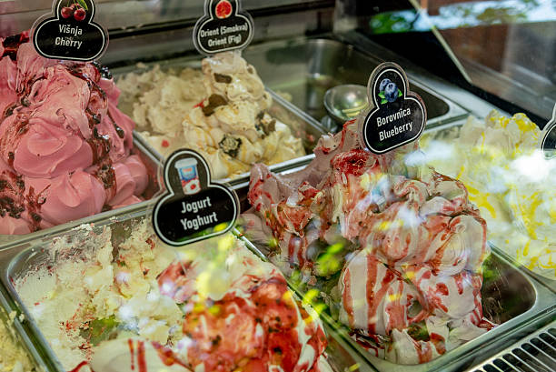 istock Various Colored Fruit Delicious Ice Cream in Containers on Display Case for Sale 2224609389