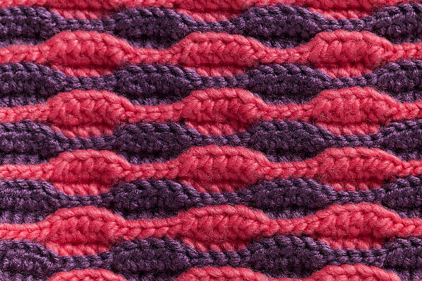 istock Knitted fabric background. Purple pink crochet volume wave pattern. 2224609681