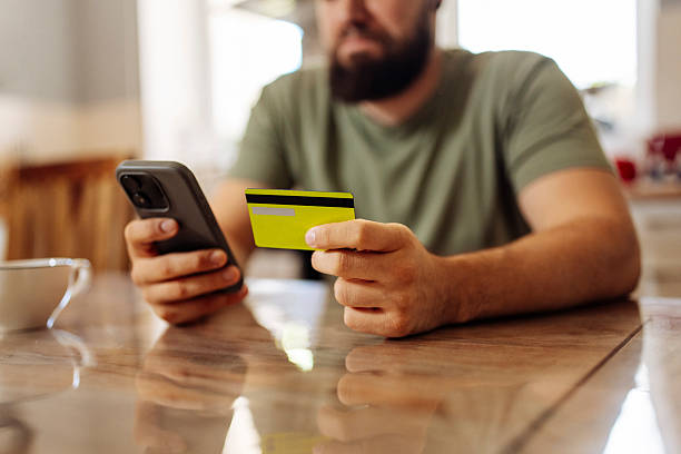 istock Bearded Man Using Smartphone and Credit Card 2224613599