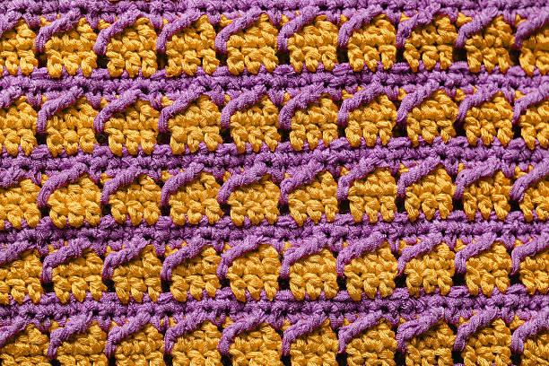 istock Yellow violet seamless knitted texture. Cross over stitch pattern. Volumetric crochet striped pattern. Knitted background. 2224613726