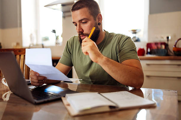 istock Focused Man Managing Finances with Laptop and Paperwork 2224614700