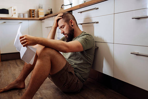 istock Stressed Man Reviewing Bills at Home 2224615324