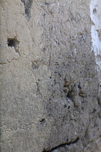 istock Cracked corner of a house wall damaged, with sky and tree branches background 2224615670