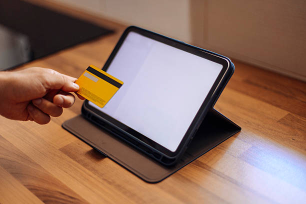 istock Hand Holding Card Near Tablet 2224615815