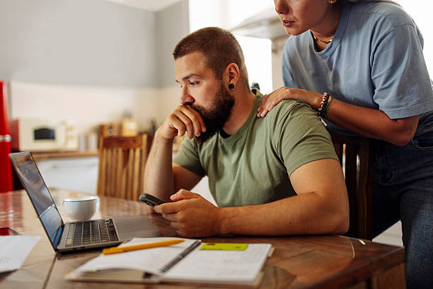 Focused Man Managing Finances on Laptop at Home