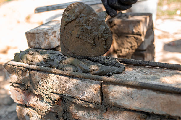 istock applying wet cement to brick structure showing texture and process of barbecue construction, close-up 2224616422
