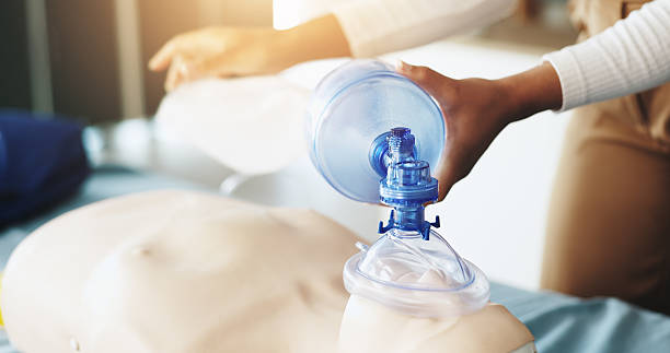 istock Oxygen, first aid and hands with mask, class and lesson to help in emergency, dummy and demonstration. Healthcare, person and teaching with ventilator for mannequin, breathing and course for cpr 2224618662