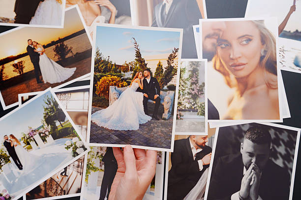 istock women's hands put on the table and show wedding photos. 2224620748
