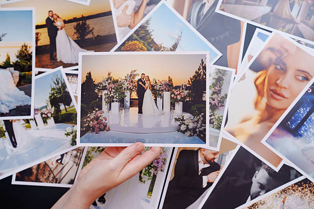 istock women's hands put on the table and show wedding photos. 2224621710