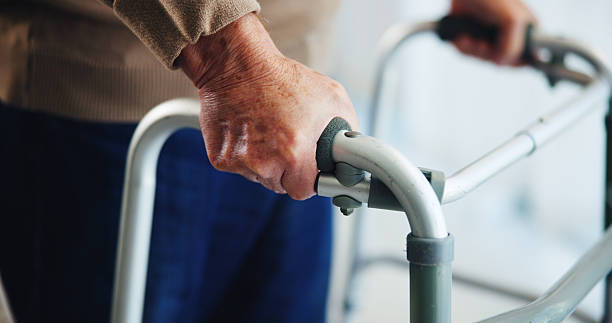 istock Walking frame, hands and senior man in home for help, support and mobility assistance. Retirement, health and closeup of person with disability with cane for wellness, injury recovery and balance 2224624534