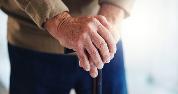 istock Walking stick, hands and senior man in home for help, support and mobility assistance. Retirement, health and closeup of person with disability with cane for wellness, injury recovery and balance 2224624540